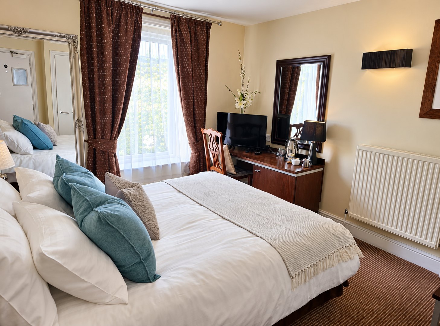 Guest bedroom at The Swan at Compton with a made double bed and warm lamplight